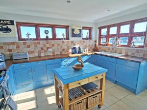 a kitchen with blue cabinets and a blue island at Flag House - Ukc7074 in Brundall