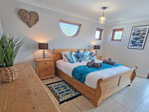 a bedroom with a large bed with blue pillows at Flag House - Ukc7074 in Brundall