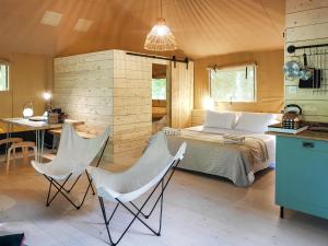 a bedroom with a bed and two white chairs at The Bushel - Ukc7131 in Cratfield
