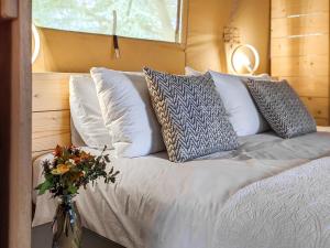 a bed with pillows and a vase of flowers on it at The Bushel - Ukc7131 in Cratfield