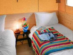 a bedroom with a bed with a colorful blanket on it at The Bushel - Ukc7131 in Cratfield +2 photos