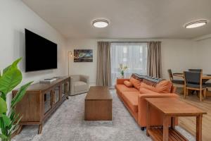 a living room with a couch and a flat screen tv at Downtown 1 Bedroom Flat with Views in Anchorage