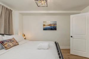 a bedroom with a white bed and a white door at Downtown 1 Bedroom Flat with Views in Anchorage +17 photos