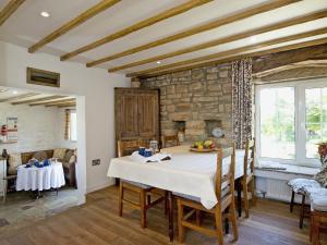 a dining room with a table and a stone wall at Limber View in Glaisdale