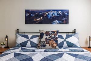 a bed with two pillows and a picture on the wall at King Bed Studio-Downtown Getaway in Anchorage