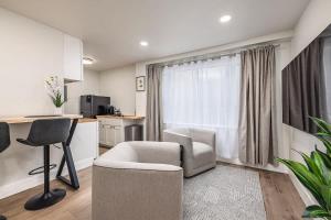 a living room with a couch and chairs and a kitchen at King Bed Studio-Downtown Getaway in Anchorage