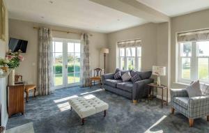 a living room with a couch and chairs and windows at The Dower House in Thorpeness