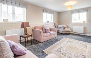 a living room with a couch and chairs and windows at The Dower House in Thorpeness