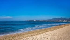 a beach with the ocean and mountains in the background at Maralma Bucerias 1 half Blocks from Beach Sleeps 4 in Bucerías +54 photos