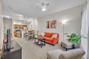 a living room with an orange couch and a kitchen at Casa Santa Maria in Kissimmee