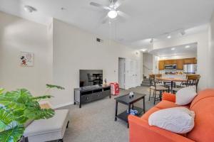 a living room with an orange couch and a table at Casa Santa Maria in Kissimmee
