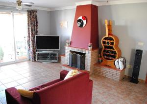 uma sala de estar com um sofá e uma lareira com uma guitarra em Bed & Breakfast Finca de los Sueños em Alhaurín de la Torre