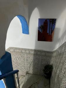 a room with a blue chair and a picture on the wall at maison bleu hajja in Tangier