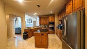 a kitchen with wooden cabinets and a stainless steel refrigerator at Elegant, comfy, a retreat with Pool in Garland