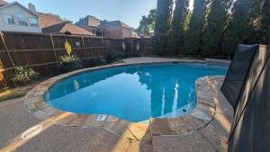 a swimming pool in a backyard with a fence at Elegant, comfy, a retreat with Pool in Garland