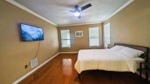 a bedroom with a bed and a ceiling fan at Elegant, comfy, a retreat with Pool in Garland +23 photos