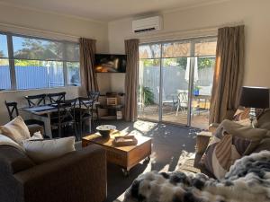 a living room with two couches and a table and a dining room at Two Tree Motel & Lodge in Blenheim