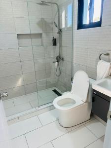 a white bathroom with a shower and a toilet at Luma Residence in San Felipe de Puerto Plata