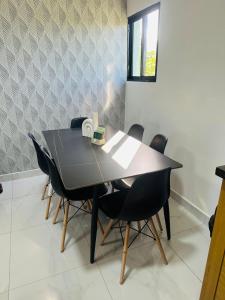 a black dining room table with black chairs at Luma Residence in San Felipe de Puerto Plata +3 photos