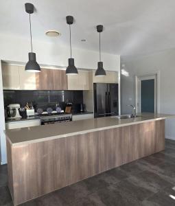 a large kitchen with a large island in the middle at Quiet Homestay Ulladulla in Ulladulla
