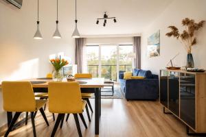 a dining room and living room with a table and chairs at Sea View & SPA 10d10 in Dziwnów