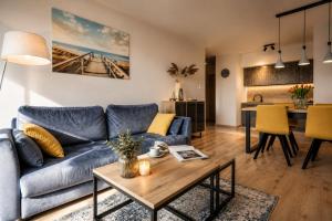 a living room with a blue couch and a table at Sea View & SPA 10d10 in Dziwnów
