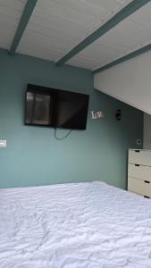 a bedroom with a bed and a flat screen tv on the wall at Cozy Fjord Loft in Reyðarfjörður