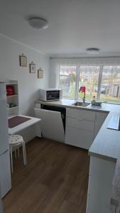a white kitchen with a sink and a stove at Cozy Fjord Loft in Reyðarfjörður