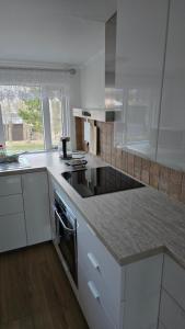 a kitchen with white cabinets and a counter top at Cozy Fjord Loft in Reyðarfjörður