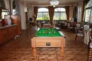 Una habitación con una mesa de billar con pelotas. en Hôtel Beau Site en Malbuisson