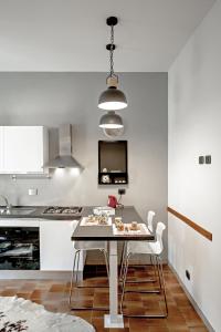 een keuken met een tafel met stoelen en een televisie bij Casa indipendente immersa nel verde in Rome