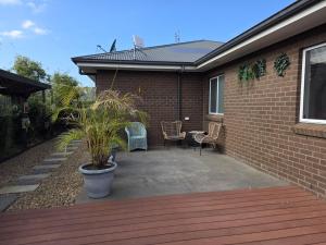 a patio with two chairs and a house at Quiet Homestay Ulladulla in Ulladulla +4 photos