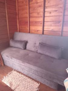 a gray couch with two pillows in a room at Recanto do SOL in Imaruí