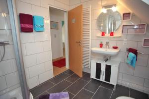 a bathroom with a sink and a mirror at Ferienhaus Victoria in Norden +18 photos