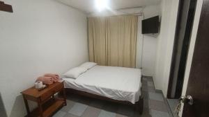 a bedroom with a bed and a nightstand with a teddy bear at Hosp Norte Los Organos in Los Órganos