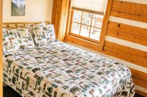 a bedroom with a bed and a window at Bearfoot Bungalow- Tiny Cabin Getaway in Sevierville
