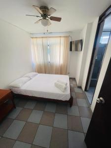 a bedroom with a bed and a ceiling fan at Hosp Norte Los Organos in Los Órganos