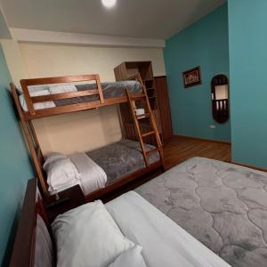 a bedroom with two bunk beds and a bed at Núba Hospedaje in Baños