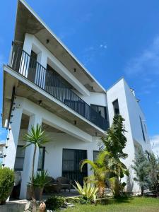 a white building with a balcony and some plants at 木木宿宿MUMUsusu-stay只接待成年者一無包棟服務 in Taitung City