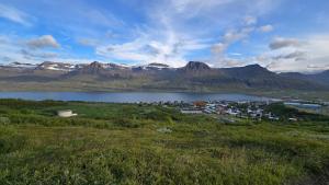 a small town next to a body of water with mountains at Cozy Fjord Loft in Reyðarfjörður