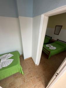 a room with two green beds in a room at Malibu in Termas de Río Hondo