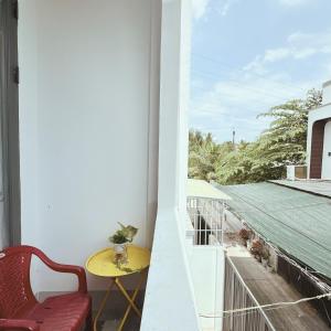 a balcony with a yellow table and a yellow chair at La Maison de My Tho in Mỹ Tho