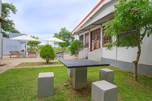a bench in the grass in front of a building at Wild Le Green in Udawalawe