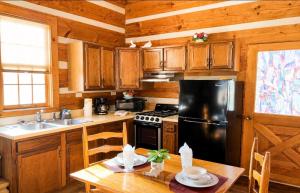 a kitchen with wooden cabinets and a stainless steel refrigerator at Beary Cozy- Tiny Cabin Getaway! in Sevierville