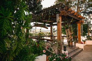 a wooden pergola in a garden with plants at Villa Vassallo in Ponce