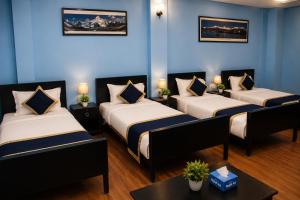 two beds in a room with blue walls at Second Home Hotel in Kathmandu