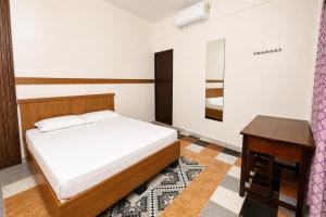 a bedroom with a bed and a table at Noble Darshan in Guruvāyūr