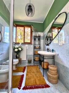 a bathroom with a sink and a toilet and a mirror at Elegant Penthouse LA BALCONATA - Wellness Retreat & Castle View in Tabiano +197 photos