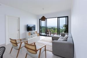 a living room with a couch and a table and chairs at The Friendly Condo by AcoModo Punta Caelo in El Nance
