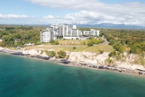 an aerial view of a building on a cliff near the water at The Friendly Condo by AcoModo Punta Caelo in El Nance